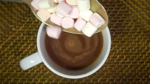 Mini marshmallows being added to a cup of cocoa, hot chocolate or coffee. Stock Footage 301784335