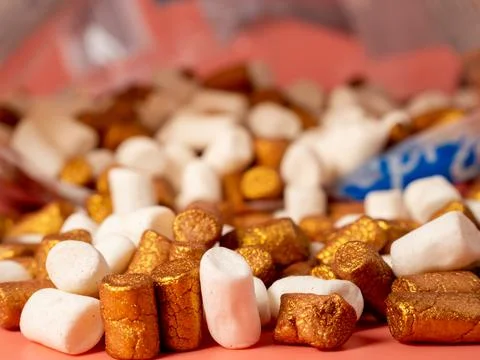 Mini marshmallows on a pink background. Marshmallow gold and white. Stock Photos