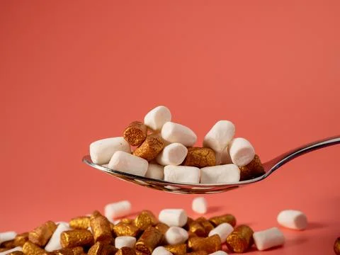 Mini marshmallows on a pink background. Marshmallow gold and white. Stock Photos