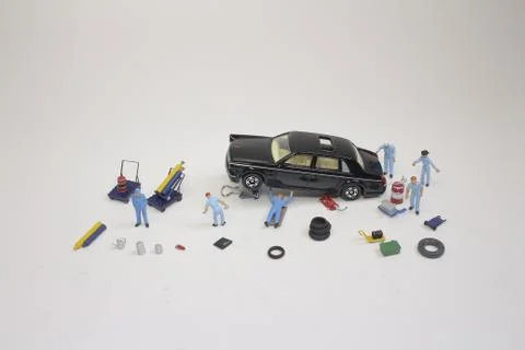 A mini mechanics replacing a punctured tyre of a car 스톡 사진