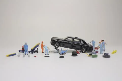 A mini mechanics replacing a punctured tyre of a car 스톡 사진