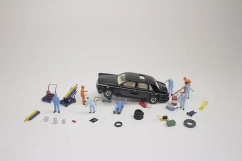A mini mechanics replacing a punctured tyre of a car 스톡 사진