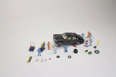 A mini mechanics replacing a punctured tyre of a car 스톡 사진