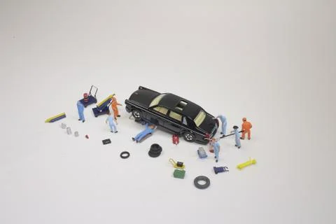 A mini mechanics replacing a punctured tyre of a car 스톡 사진