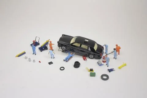 A mini mechanics replacing a punctured tyre of a car 스톡 사진