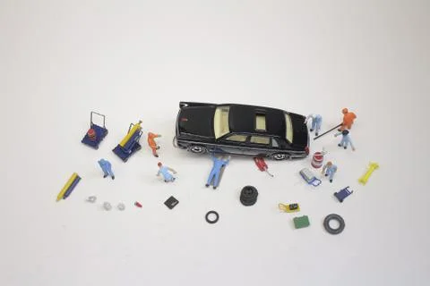 A mini mechanics replacing a punctured tyre of a car 스톡 사진