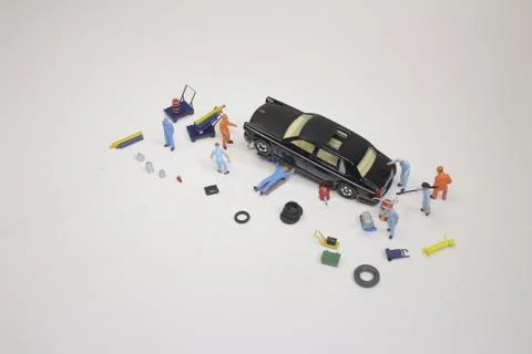 A mini mechanics replacing a punctured tyre of a car Foto stock