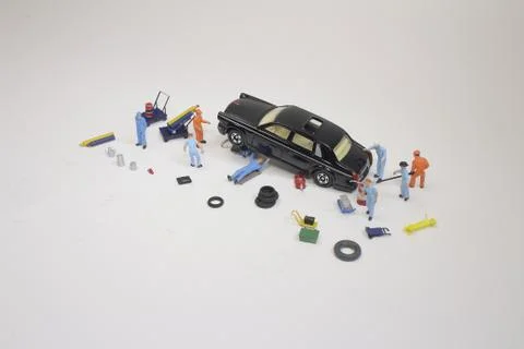 A mini mechanics replacing a punctured tyre of a car 스톡 사진