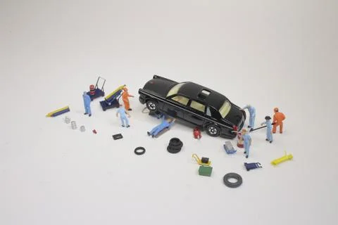 A mini mechanics replacing a punctured tyre of a car 스톡 사진