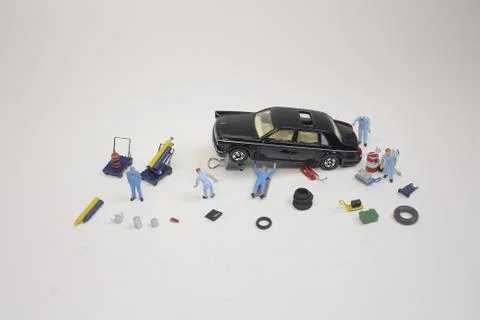 A mini mechanics replacing a punctured tyre of a car 스톡 사진