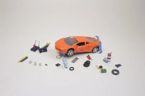 A mini mechanics replacing a punctured tyre of a car 스톡 사진