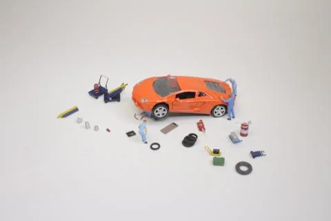 A mini mechanics replacing a punctured tyre of a car 스톡 사진