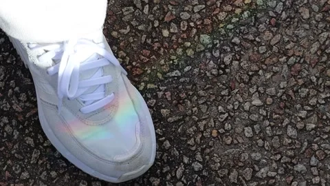 Mini miniature rainbow shining on a white sneaker on the ground Stock Footage 228408333