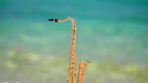 Mini model of real alt tenor saxophone stands white small pebbles on seashore Stock Footage 147922493
