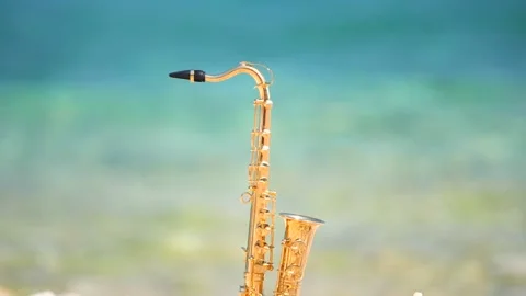 Mini model of real alt tenor saxophone stands white small pebbles on seashore Stock Footage 147924258