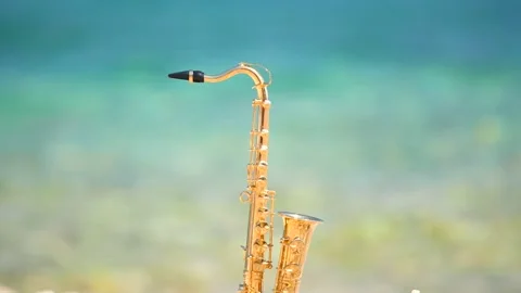 Mini model of real alt tenor saxophone stands white small pebbles on seashore Stock Footage 147925072