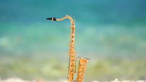 Mini model of real alt tenor saxophone stands white small pebbles on seashore Stock Footage 147926400