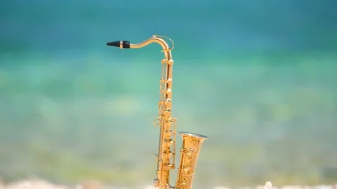 Mini model of real alt tenor saxophone stands white small pebbles on seashore Stock Footage 147926502