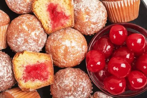 Mini Muffins with cherry jam on black plate Stock Photos