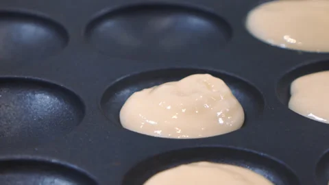 Mini pancake toaster. Process for making a mini pancakes. Hand of a girl pouring Stock Footage 179001496