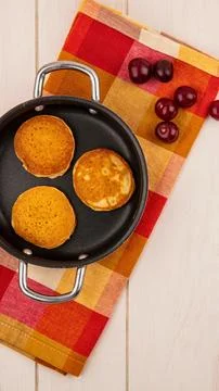 Mini pancakes cooked in a small pan with grapes on a colorful napkin Stock Photos