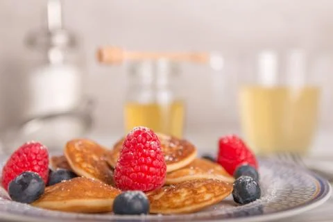 Mini pancakes with fruit and honey Stock Photos