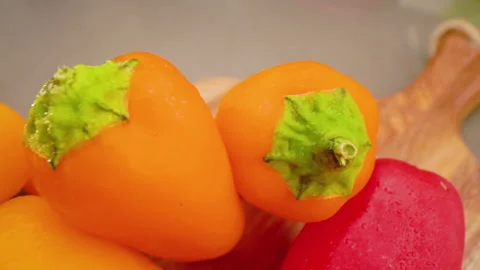 Mini Peppers Pull Back Above Angle on Cutting Board Macro Stock Footage 156054795