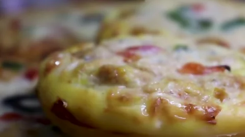 Mini pizzas with melted cheese and toppings captured in warm Stock Footage 338164322