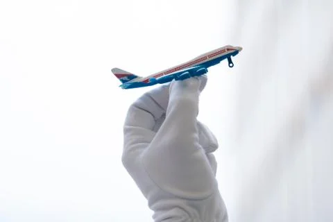 The mini plane's layout is in the hands of a flight attendant in white gloves Stock Photos