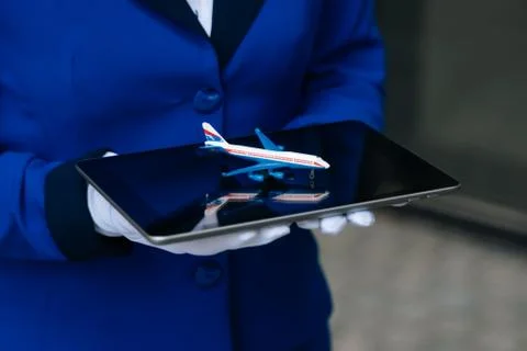 The mini plane's layout is in the hands of a flight attendant in white gloves Stock Photos