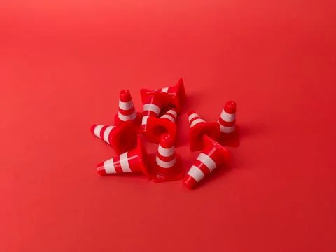 Mini plastic cones scattered on a red background Stock Photos