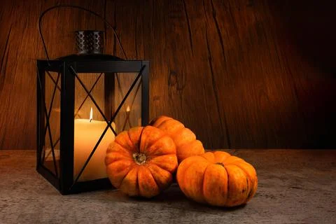 Mini Pumpkins Beside Black Lantern with Lit Candle on Wooden Background Stock Photos