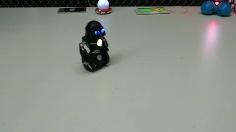 Mini robot riding on a table, making a turn and going out of frame Stock Footage 67250939