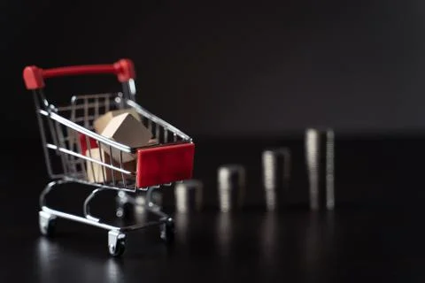 Mini shopping cart with coins stack. Stock Photos