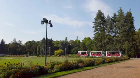 A mini sightseeing train with tourists runs in a beautiful park Video stock 132507563