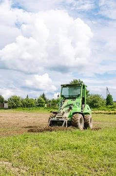 Mini skid steer loader clear a construction site. Small tractor with a ground Foto stock