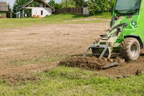 Mini skid steer loader clear a construction site. Small tractor with a ground Foto stock