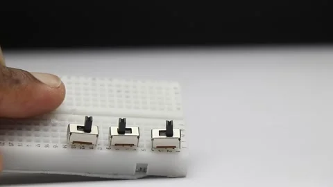 Mini slide switches connected to breadboard. Electronics components Stock Footage 344782103