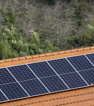 Mini small blue solar panels installation on a dark roof of a house during .. Foto stock