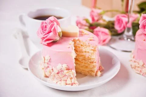 Mini small cake with pink glaze, beautiful roses, cup of coffee, gift box on  Photos