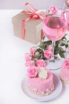 Mini small cake with pink glaze, beautiful roses, cup of coffee, gift box on  Photos