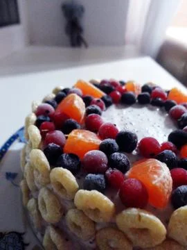 Mini sponge cake decorated with berries and corn rings Stock Photos