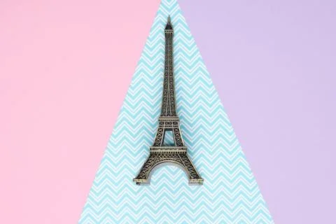 Mini statuette of the Eiffel Tower on a pastel paper background. Top view Stock Photos