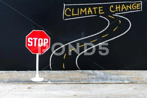 Mini STOP sign on the road to CLIMATE CHANGE Stock Photos