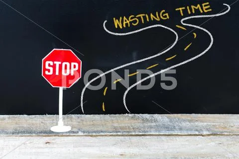 Mini STOP sign on the road to WASTING TIME Stock Photos