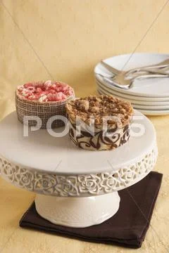 A Mini Strawberry Cakes And A Mini Caramel Cake On A Cake Stand