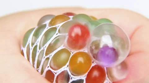 Mini stress relief balls are squeezed in the hand. Balls for relieving tension. Stock Footage 250973432