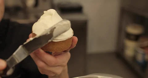 A mini-tart in the hands of a pastry chef at the time of spreading the cream. Stock Footage 251952823
