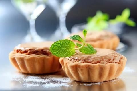 Mini tartlets with mint garnish on a table Stock Photos
