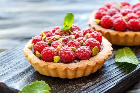 Mini tarts with chocolate, raspberry and pistachio. Stock Photos